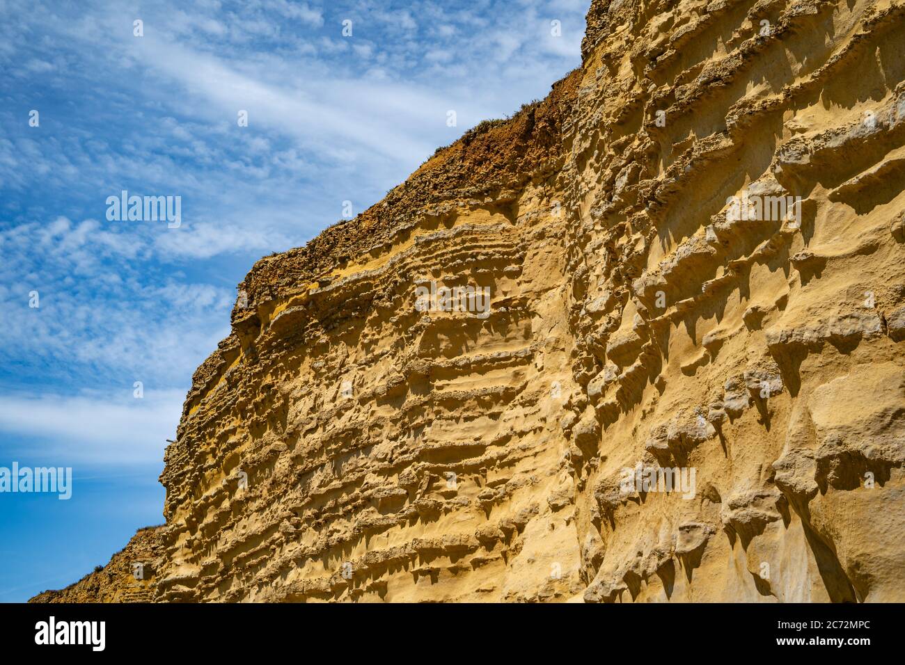 Falaises de la mer à Burton Bradstock, le début de la plage de Chesil, sur la côte jurassique de Dorset, Royaume-Uni avec ciel bleu et nuages blancs Banque D'Images