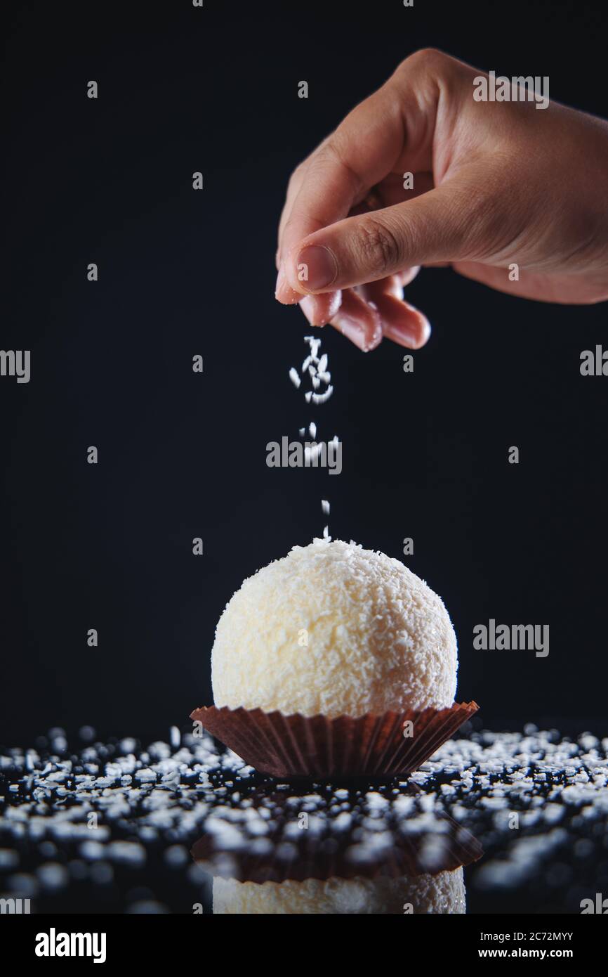 Grande Candy de noix de coco ou boule à gâteau avec garniture au chocolat blanc dans une assiette isolée Banque D'Images