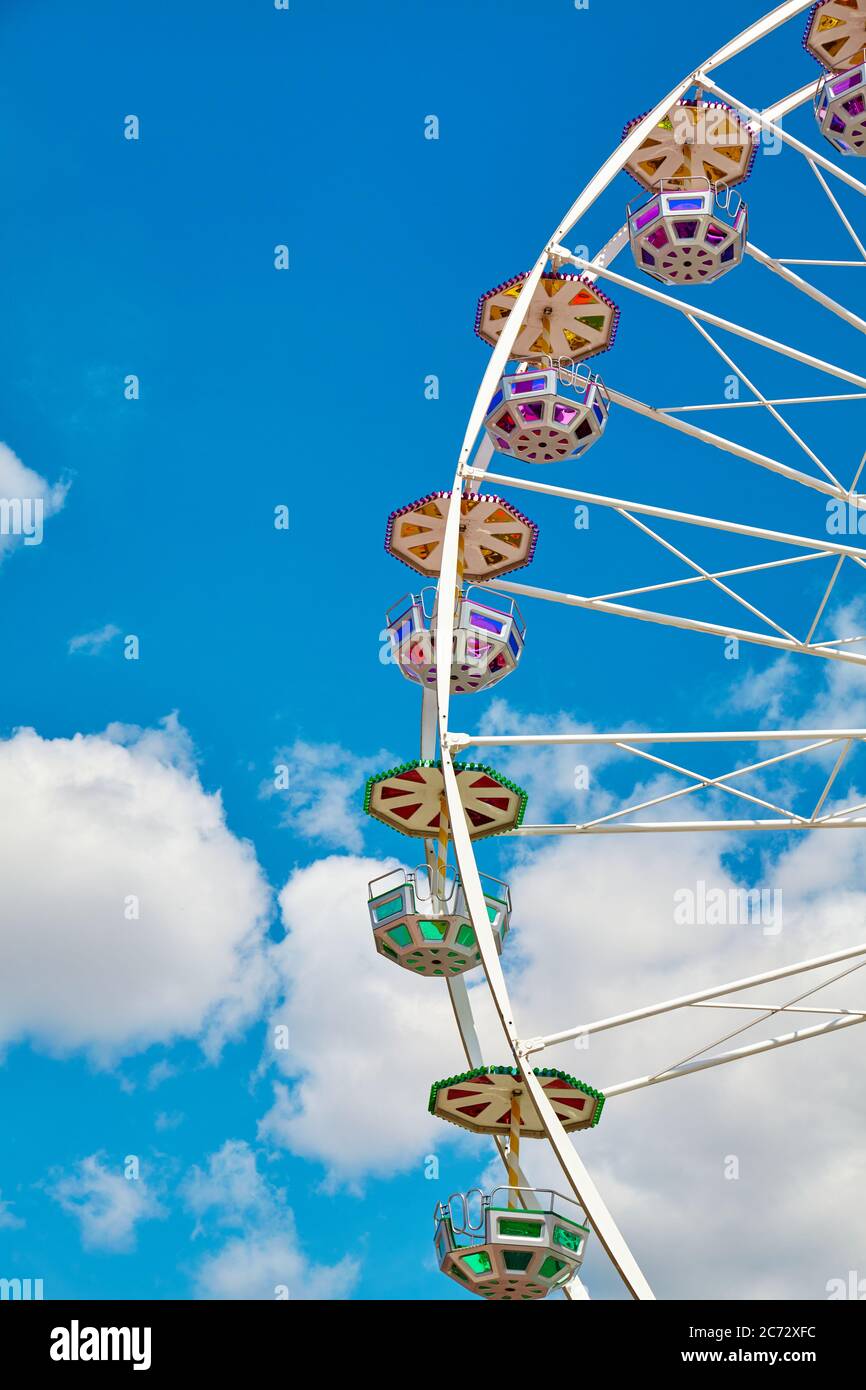 Grande roue par une journée ensoleillée avec ciel bleu et nuages en arrière-plan. Banque D'Images