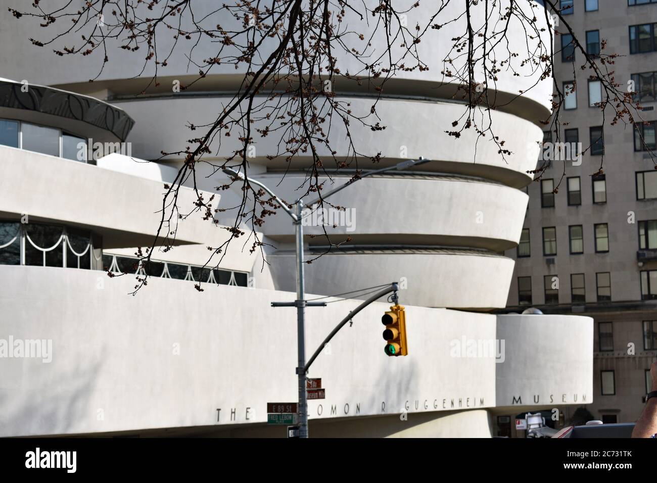 Le musée Guggenheim dans l'Upper East Side à New York. Les feux de circulation et les arbres sont au premier plan et le bâtiment blanc moderne derrière. Banque D'Images