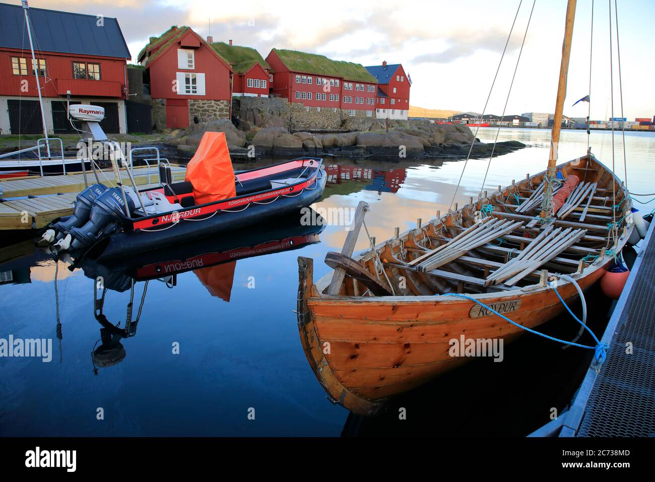 Un bateau à rames traditionnel de la région Féroé amarrant dans le port de Torshavn avec des maisons en bois à toit de gazon à Tinganes en arrière-plan.Torshavn.Streymoy.Iles Féroé.territoire du Danemark Banque D'Images