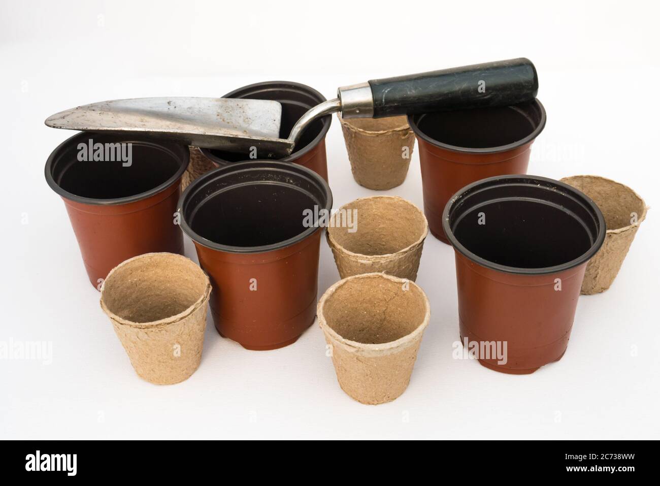 Un studio Photographie d'une truelle de jardin, pots de plantes en plastique rouge et pots de plantes en fibre biodégradable Banque D'Images