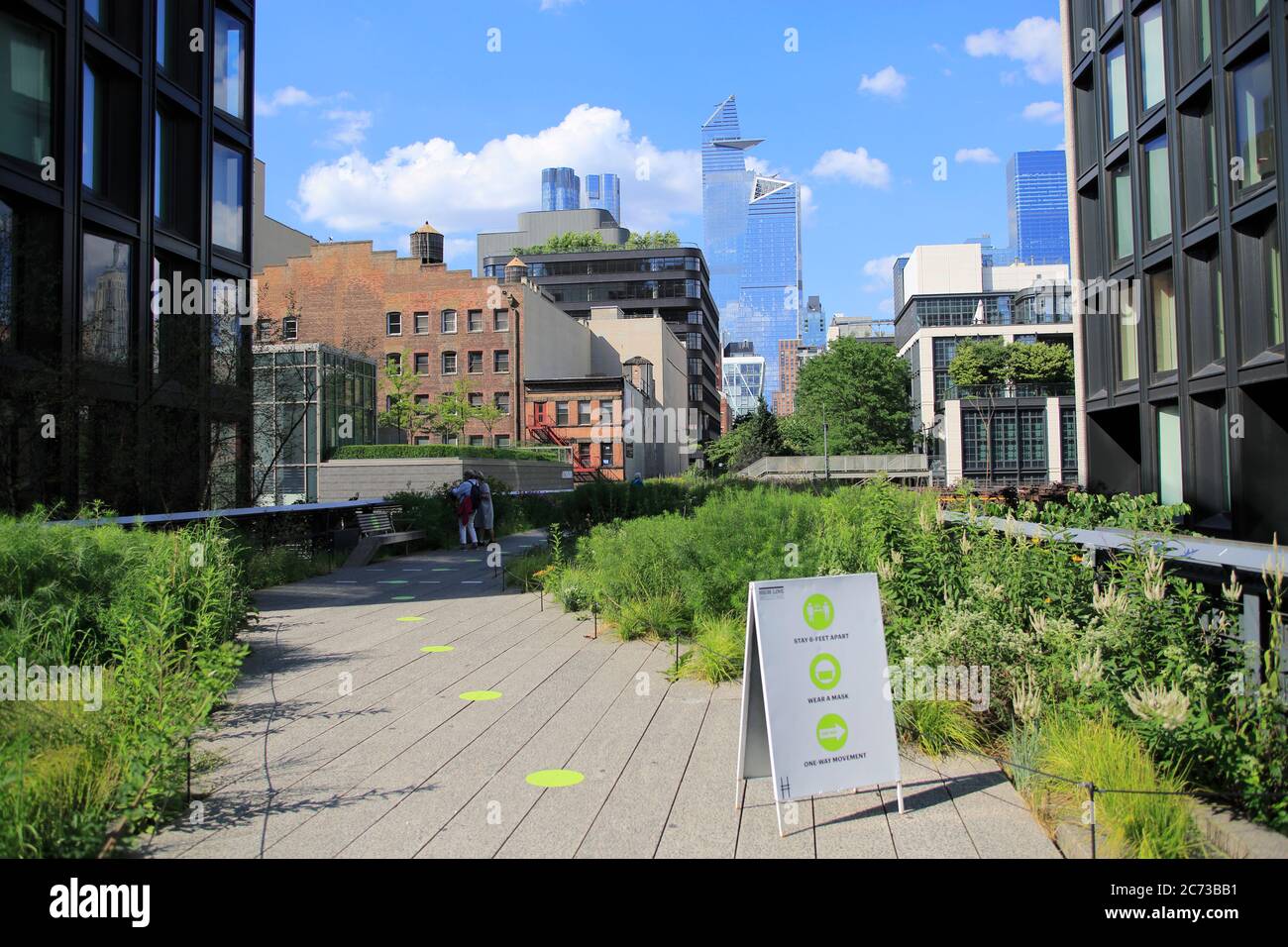High Line Park à Manhattan rouvre ses portes au public le 16 juillet avec une capacité limitée, des règles de distance sociale en place et l'obligation pour les visiteurs de porter des masques. Les cercles verts sur les passerelles aident les visiteurs à garder six pieds à l'écart. Le parc avait été fermé depuis mars pendant l'isolement de la pandémie de coronavirus. New York, États-Unis juillet 2020 Banque D'Images