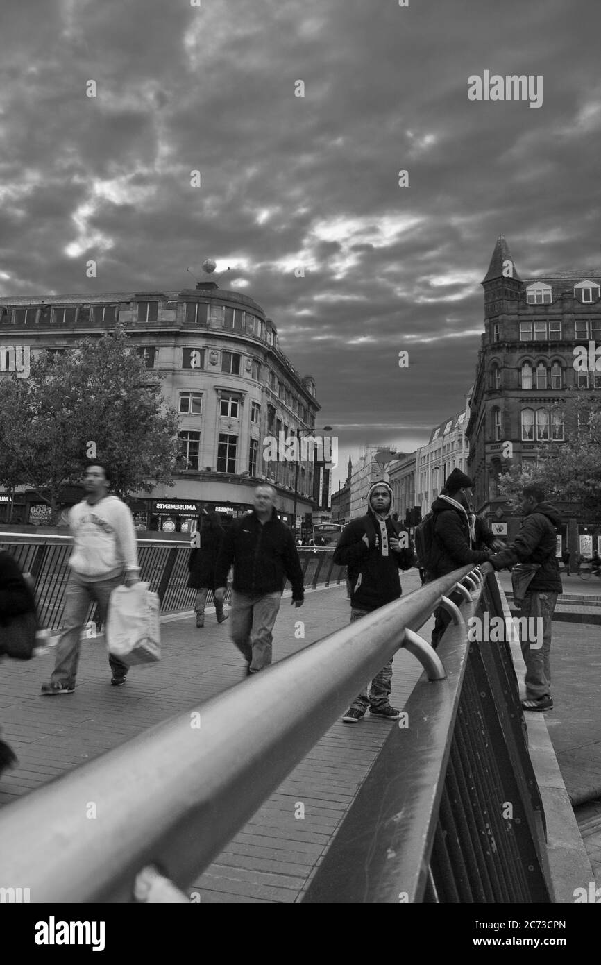Pont moderne en direction des vieux bâtiments victoriens, des acheteurs qui marchent, un groupe d'hommes bavarde en face du ciel. Plus de douceur Banque D'Images