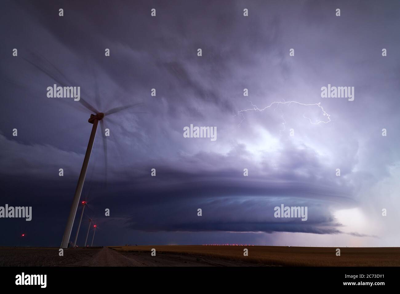 Un orage supercellulaire avec des nuages spectaculaires dans le ciel nocturne au-dessus d'un parc d'éoliennes près de Minneola, Kansas Banque D'Images