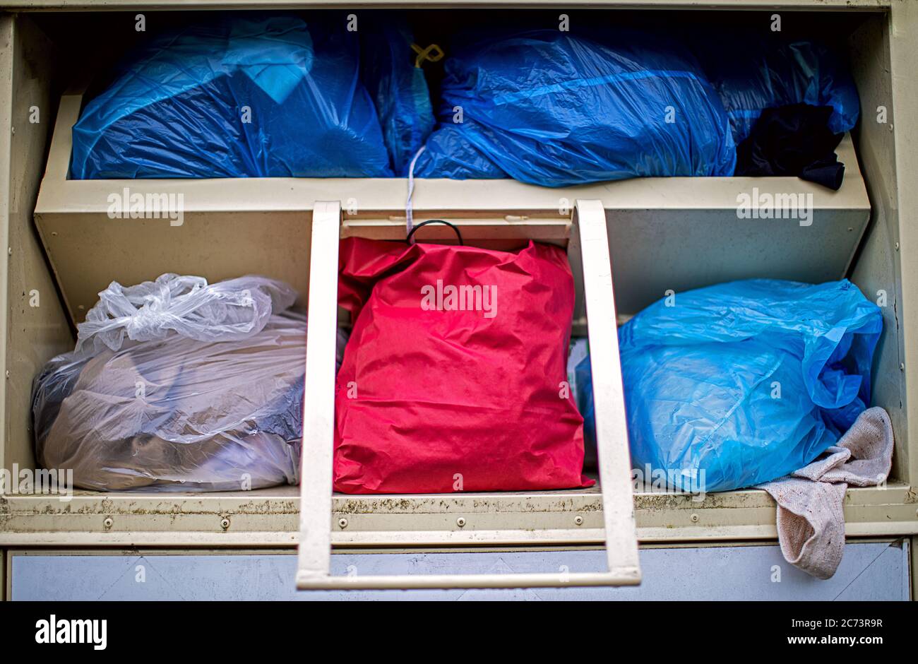 les vieux tissus et les vêtements sont livrés dans un conteneur de collecte Banque D'Images