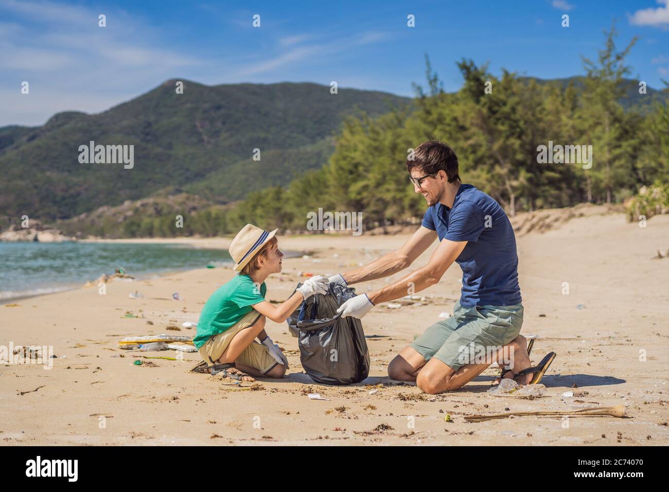 Papa et son fils en gants nettoyant la plage ramassent des sacs en  plastique qui polluent la mer. Éducation naturelle des enfants. Problème de  déchets déversés Photo Stock - Alamy