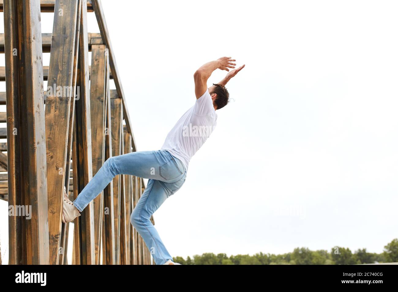 homme se penchant sur le mur avec un pied et allant à exécuter unique et dangereux cascades cool dans la rue. concept freerning. espace de copie, guy obtient r Banque D'Images