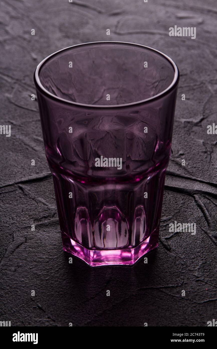 Verre sur une surface de table sombre. Banque D'Images