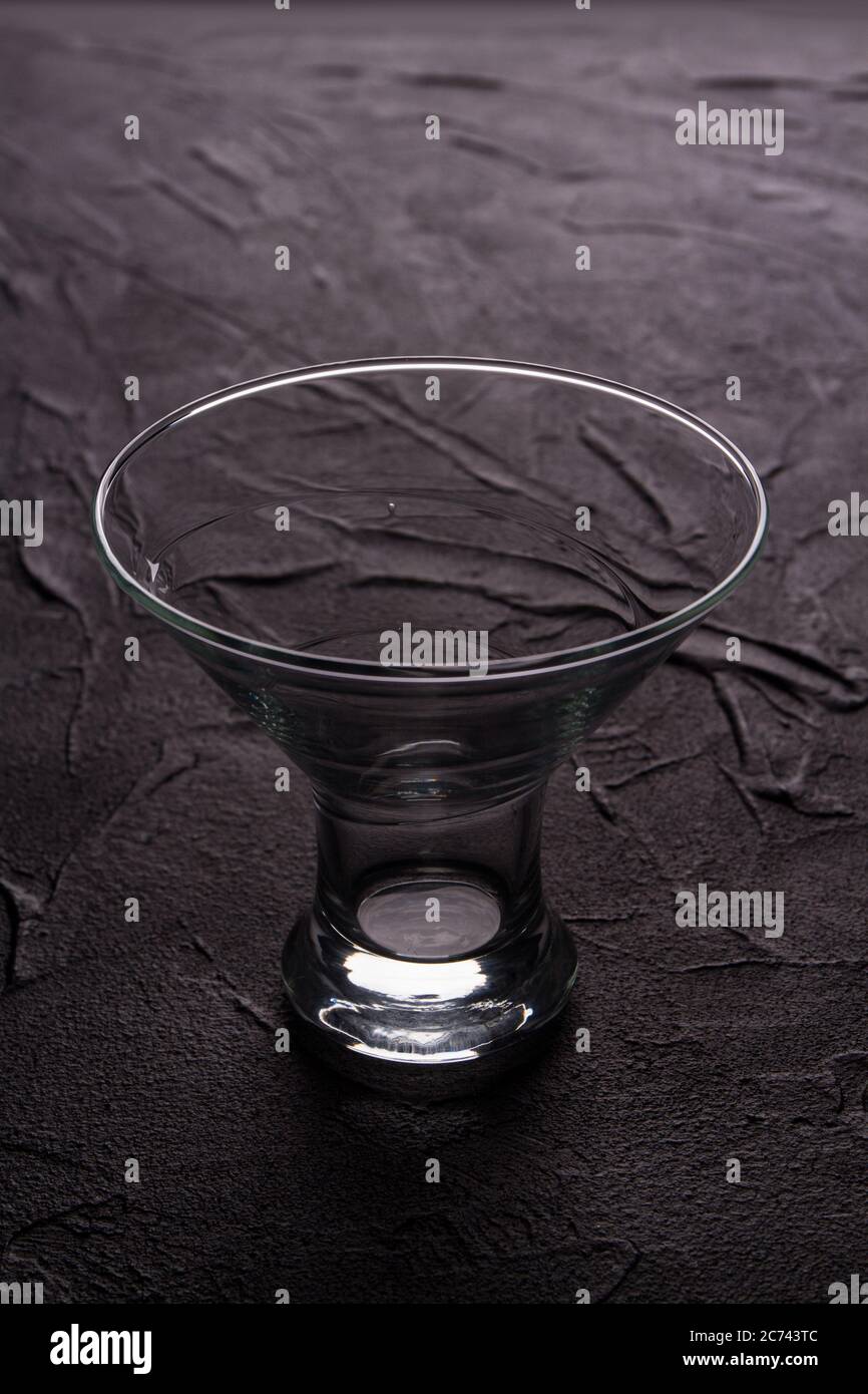 Bol en verre transparent simple sur fond gris. Banque D'Images