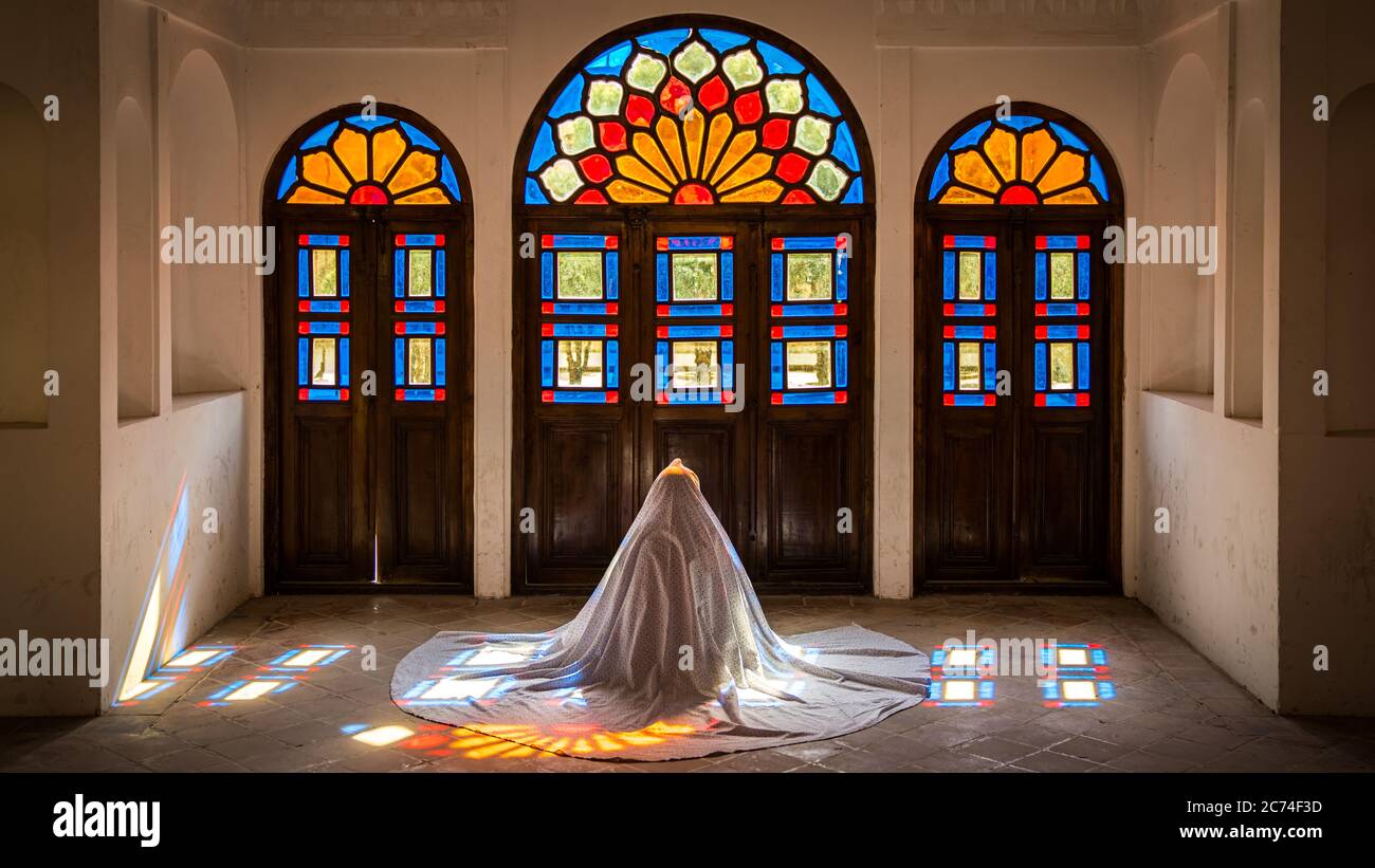Kashan, Iran - Mai 2019: Une iranienne non identifiée dans le chidor hijab priant à l'intérieur de la maison historique de Tabatabaei Natanzi Khaneh Banque D'Images