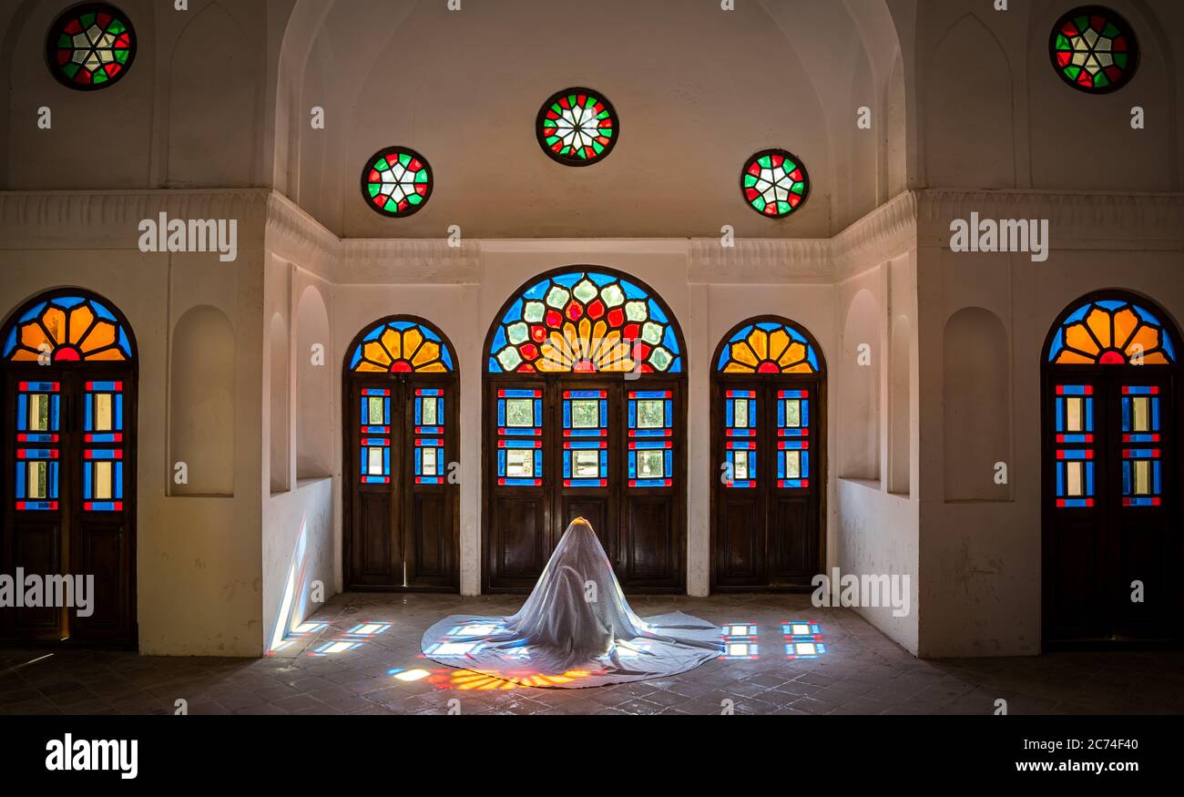 Kashan, Iran - Mai 2019: Une iranienne non identifiée dans le chidor hijab priant à l'intérieur de la maison historique de Tabatabaei Natanzi Khaneh Banque D'Images