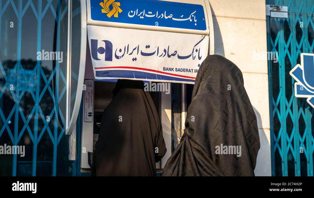Kashan, Iran - Mai 2019: Des femmes iraniennes non identifiées dans le hijab et le burka utilisant des guichets automatiques de la rue de Bank Saderat Banque D'Images