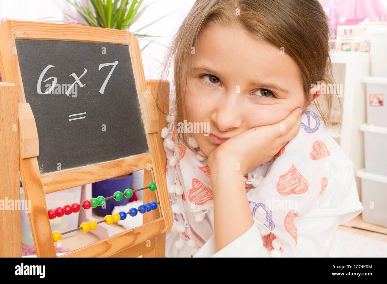 Jeune école fille frustrée, problèmes de faire des mathématiques, Allemagne Banque D'Images