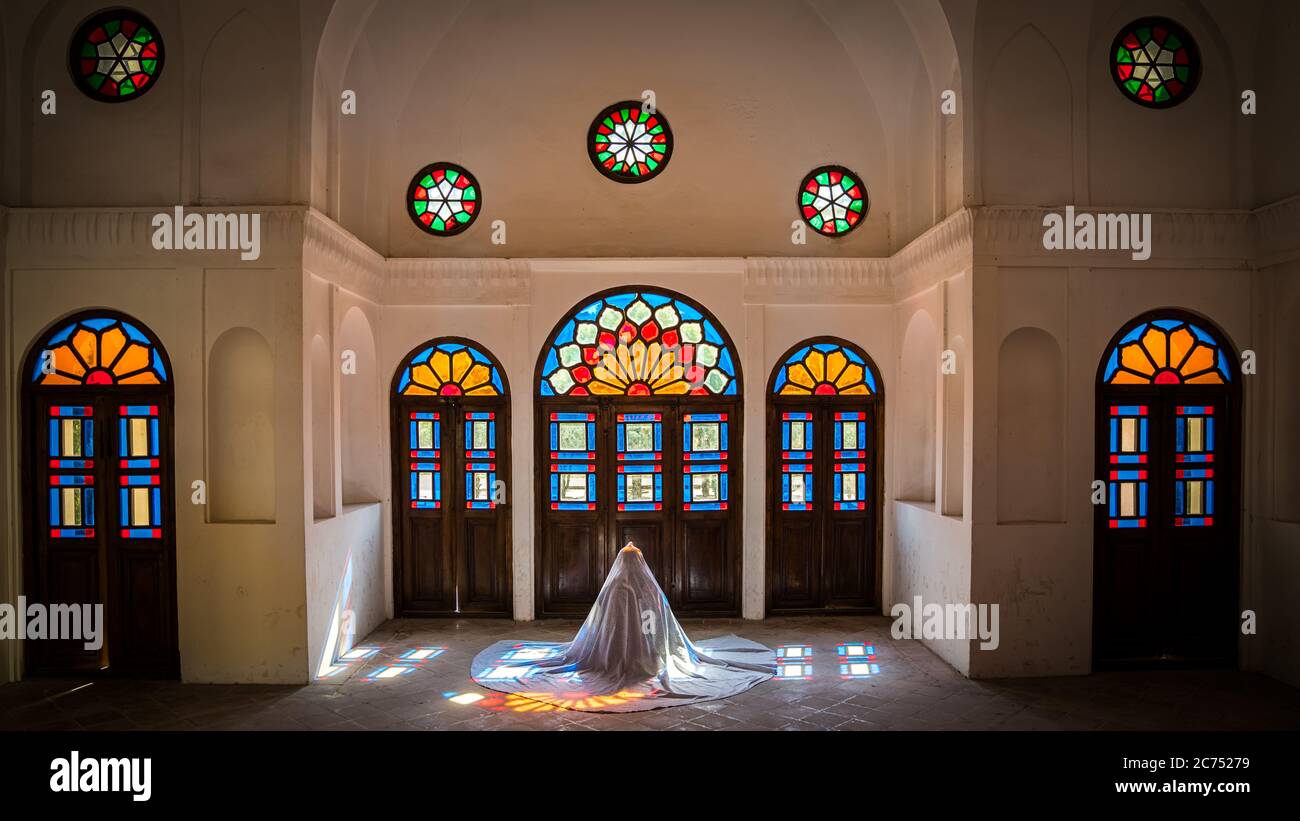 Kashan, Iran - Mai 2019: Une iranienne non identifiée dans le chidor hijab priant à l'intérieur de la maison historique de Tabatabaei Natanzi Khaneh Banque D'Images