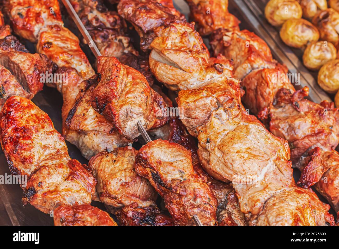 Viande de porc fraîche et juteuse sur brochettes sur un grill au charbon de bois. Vue latérale sur la viande de la gouvernail cuite sur un comptoir dans un marché de rue. Kebab de porc cuit au Barbec Banque D'Images