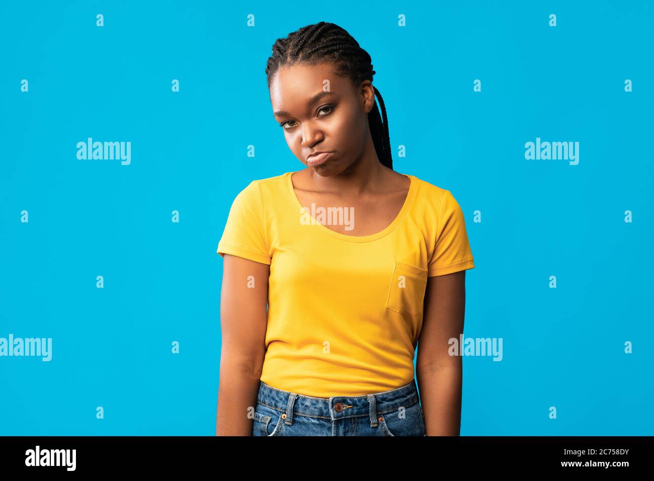 Offensé Afro-américaine fille de la choque regardant la caméra, fond bleu Banque D'Images