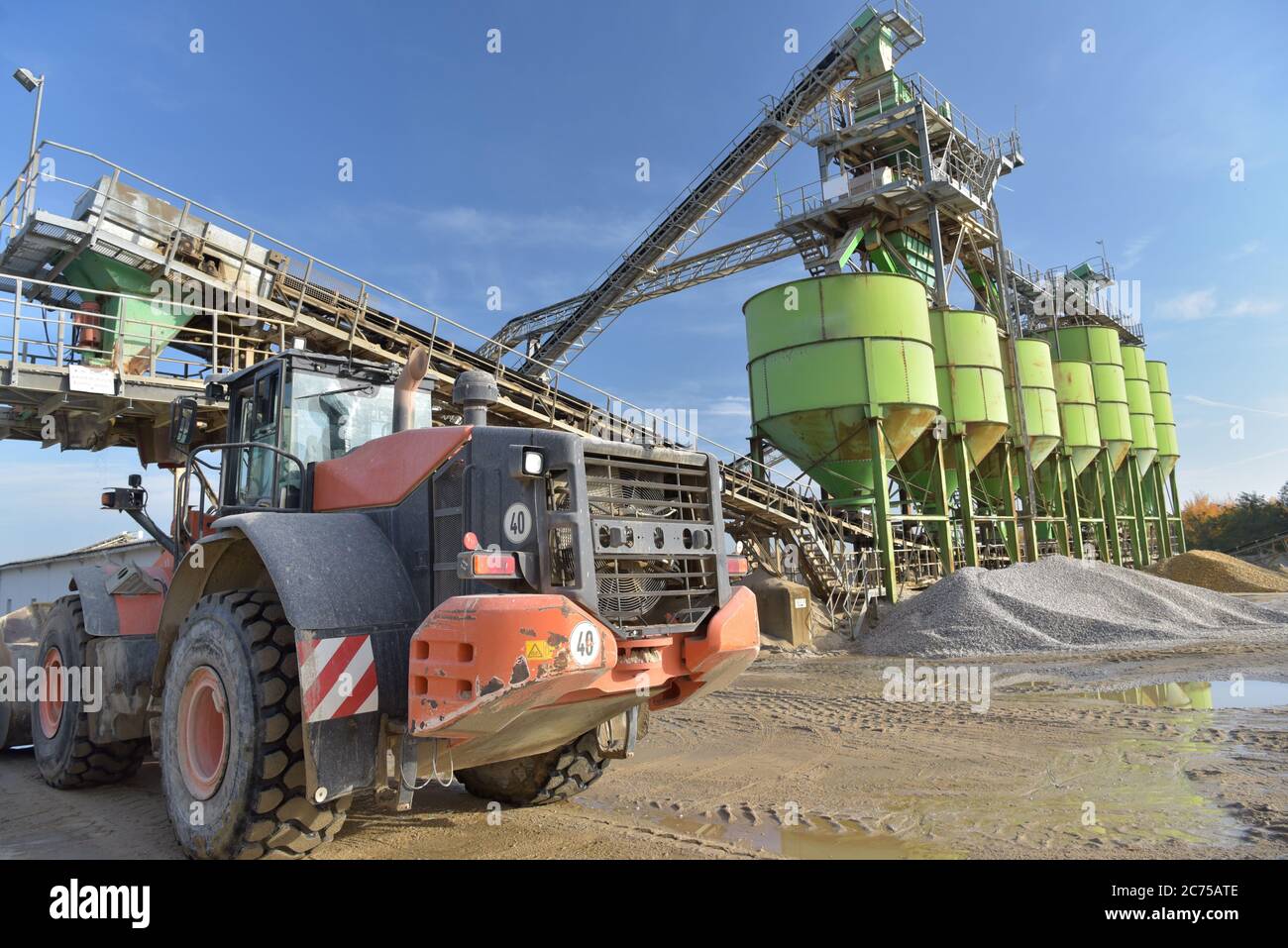 Gravier : chargement de gravier sur un camion par une chargeuse sur pneus et un bâtiment Banque D'Images