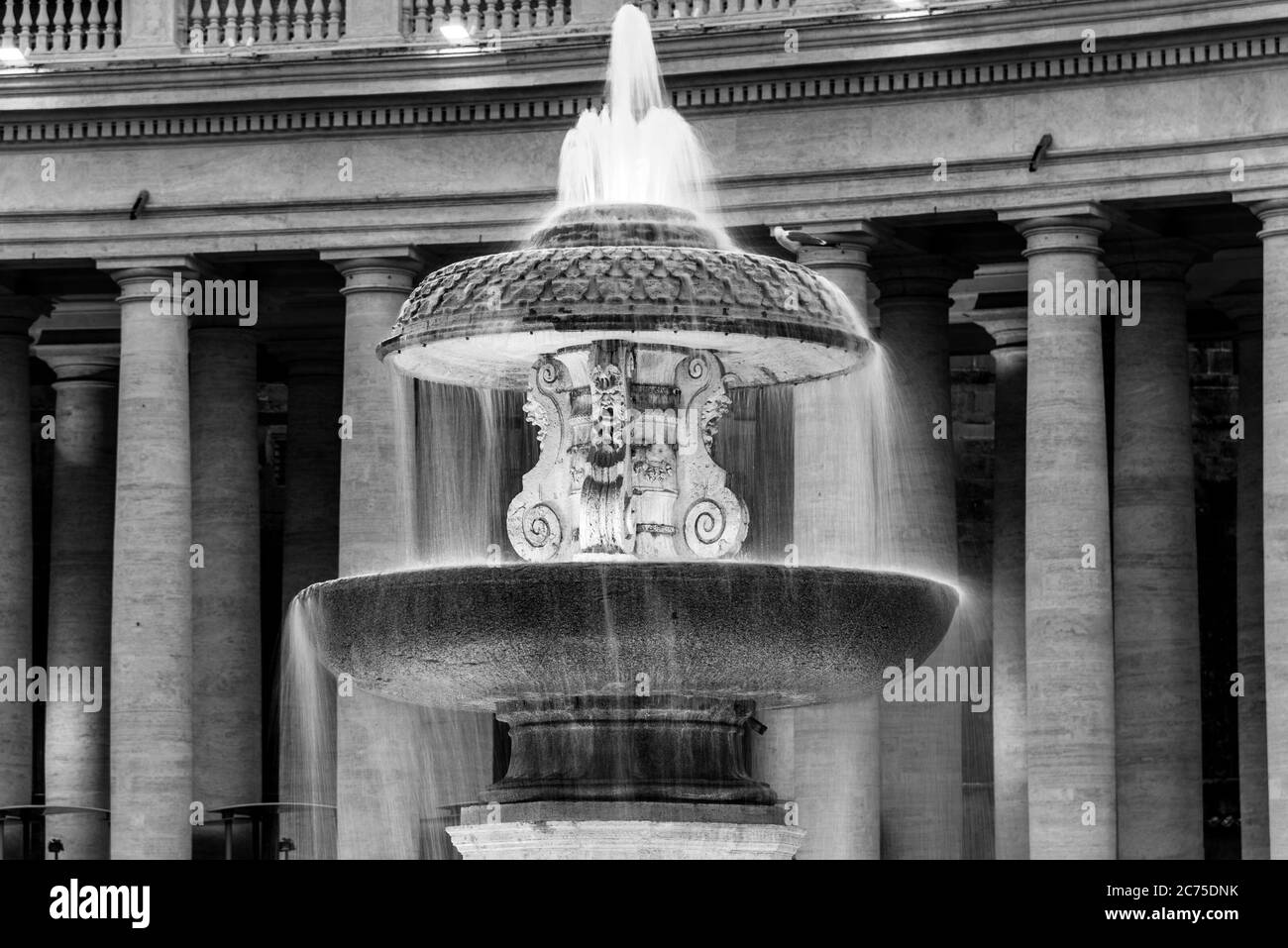 Fontaine Bernini illuminée à la basilique Saint-Pierre le soir, au crépuscule. Place Saint-Pierre, Vatican. Image en noir et blanc. Banque D'Images