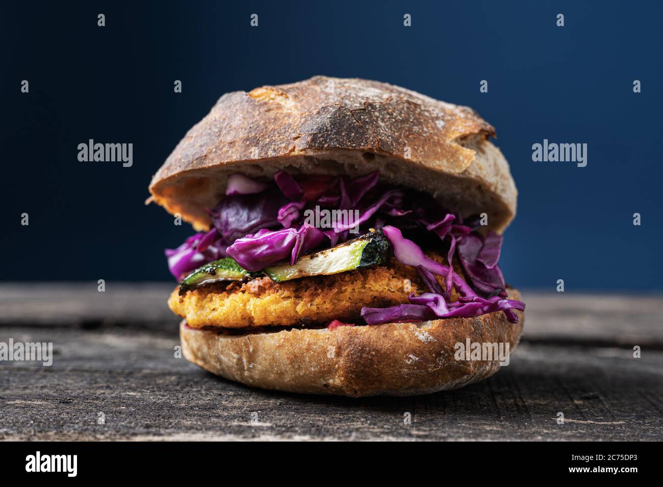 Délicieux hamburger végétarien fait maison avec courgettes grillées et chou rouge dans un pain au levain. Banque D'Images