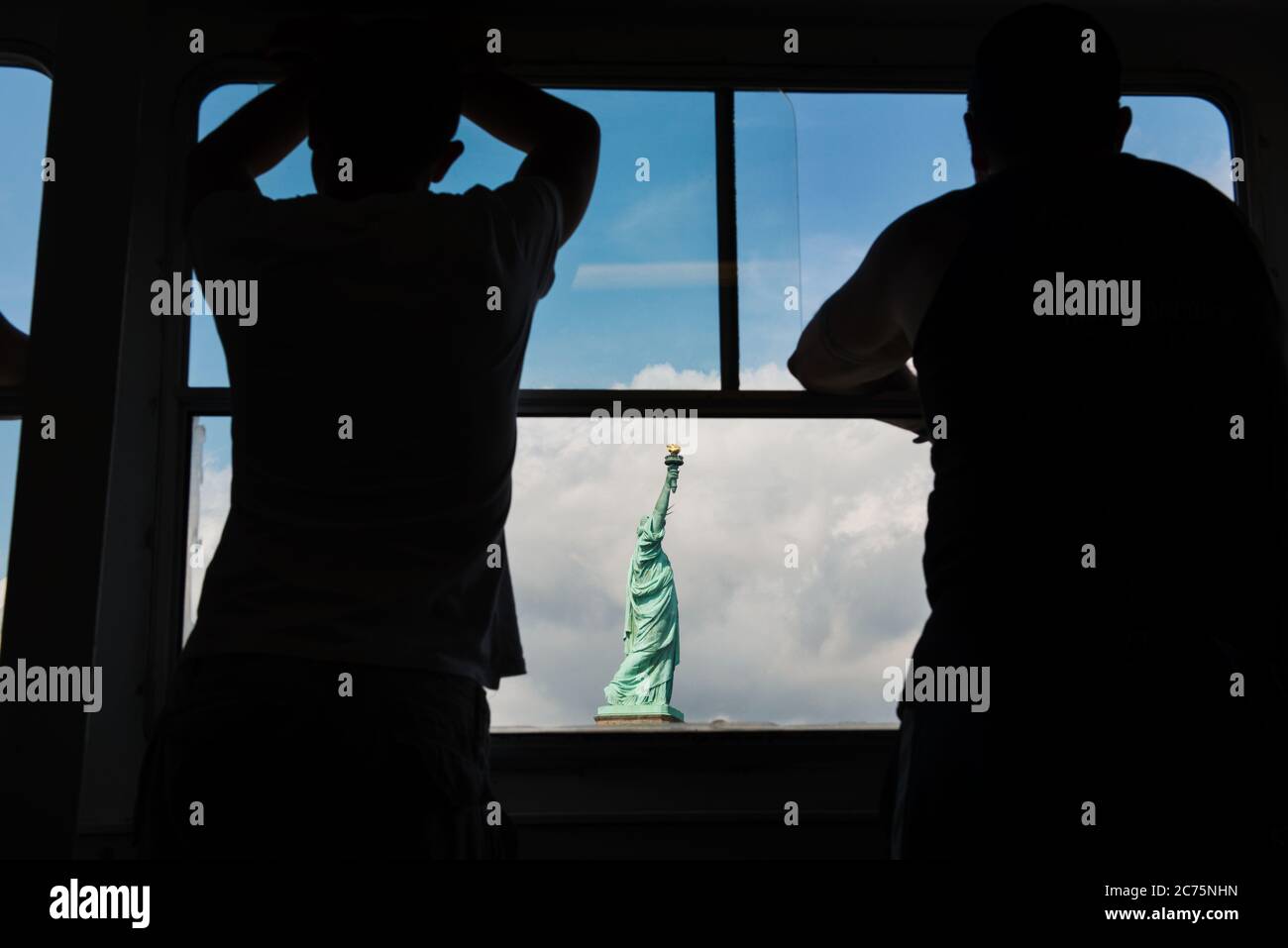 Silhouette de deux personnes en admirant la statue de la liberté depuis le ferry, New York Banque D'Images