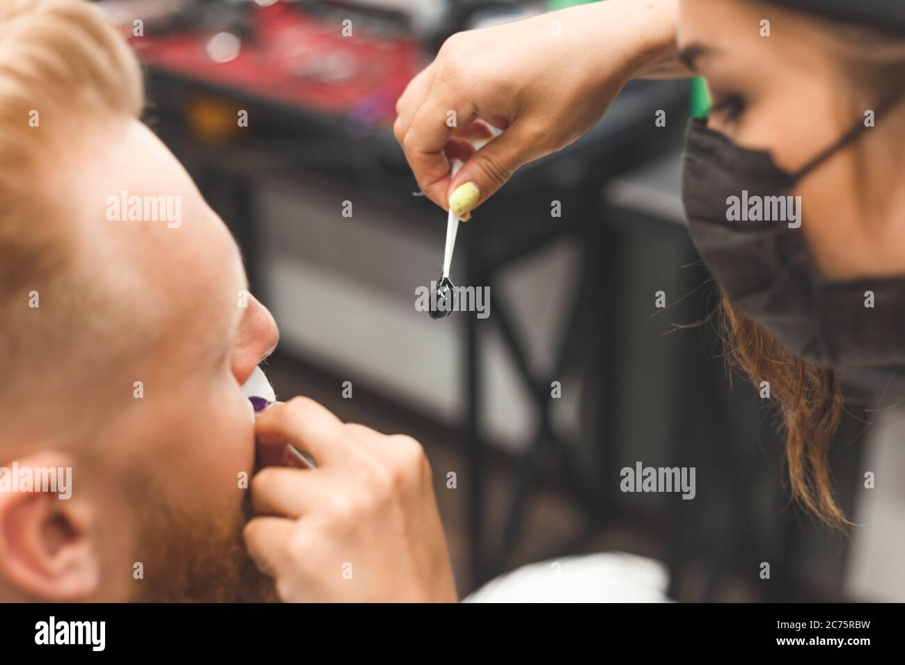 Enlever les cheveux du nez avec de la cire dans le barbershop, beauté masculine et concept de soins Banque D'Images