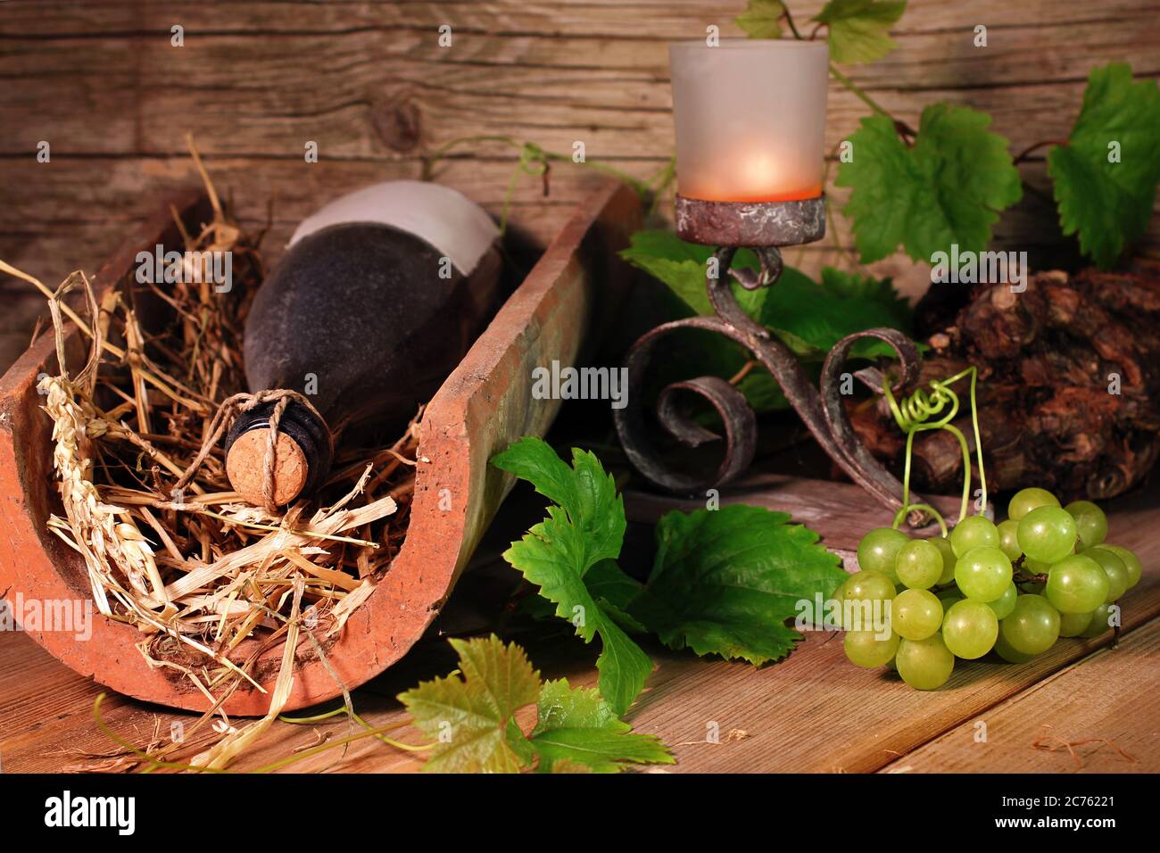 Vieille bouteille de vin sur un carreau avec des raisins Banque D'Images