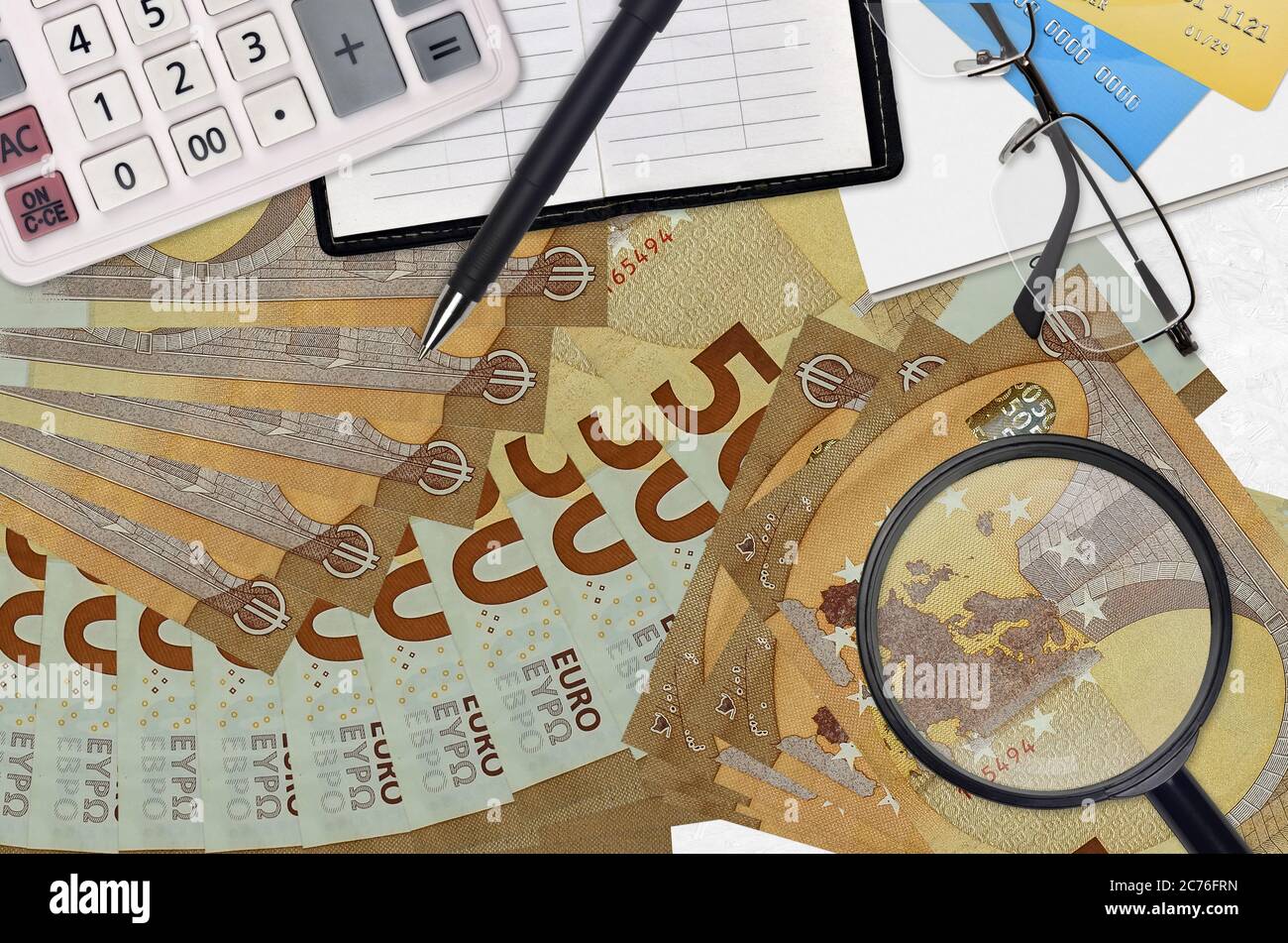 50 euros de factures et calculatrice avec lunettes et stylo. Concept de saison de paiement d'impôt ou solutions d'investissement. Recherche d'un emploi avec des salaires élevés Banque D'Images