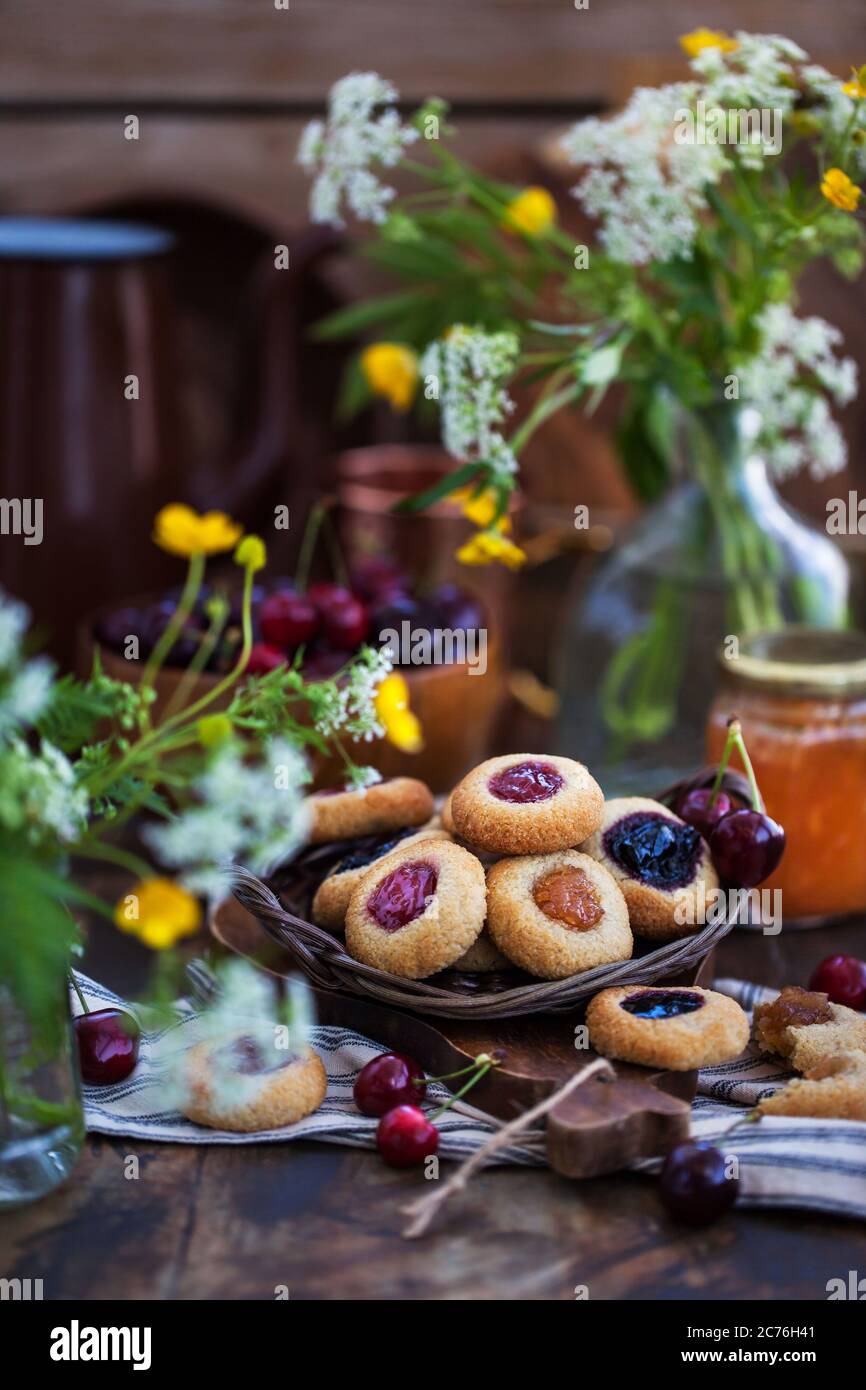 Biscuits aux amandes avec imprimé pouces et confiture sur fond de bois rustique Banque D'Images
