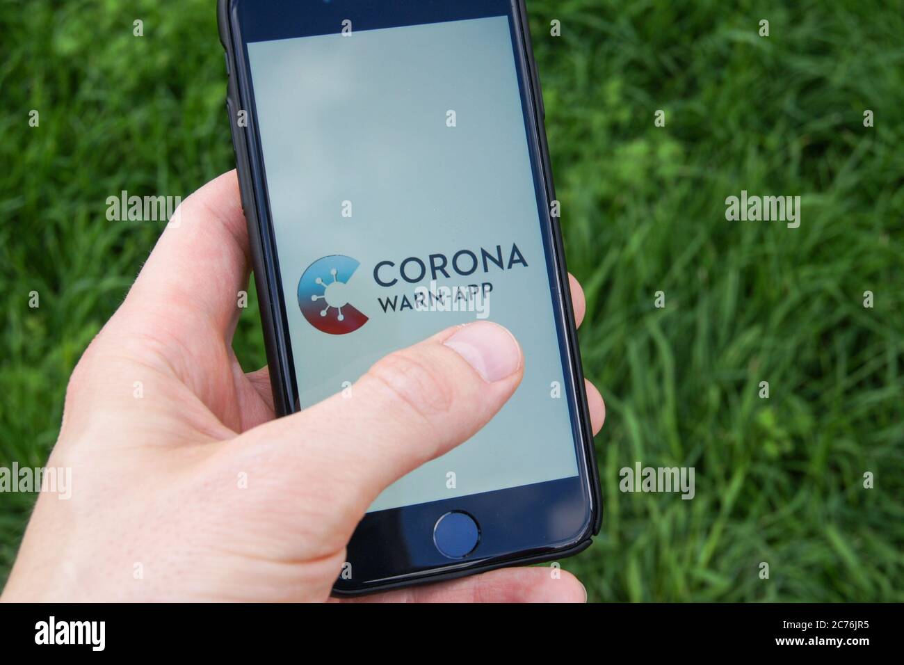 Corona Warn App du gouvernement fédéral allemand sur un smartphone tenu dans la main d'un homme. Banque D'Images