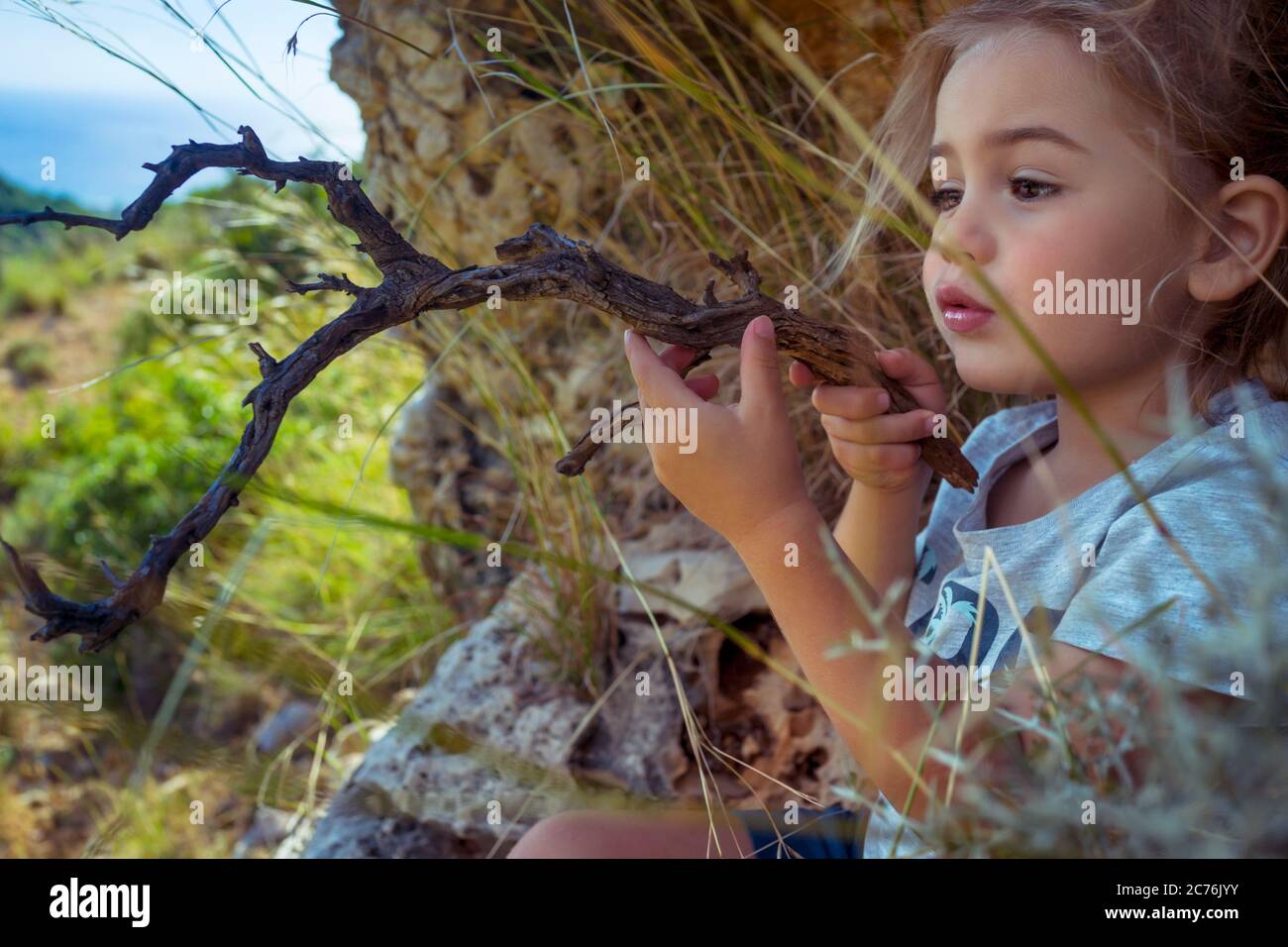 Portrait d'un petit garçon mignon jouant dans la forêt avec Magic Stick. Imagination d'un petit enfant. Enfant jouant son propre jeu. Bonne enfance de Carefree Banque D'Images