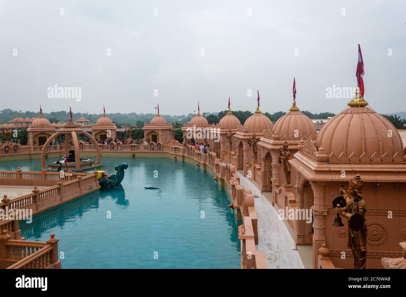 Des mandops de grès entourant l'étang artificiel avec Shivling au temple Nilkanth Dham Swaminarayan, Poicha, Gujarat, Inde Banque D'Images