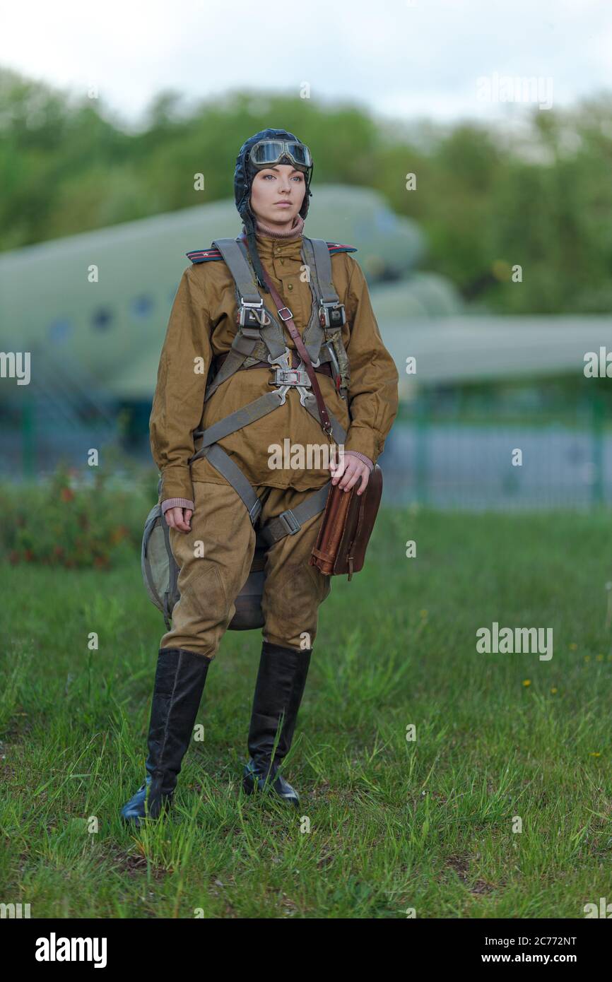 Une jeune pilote féminine en uniforme de pilotes de l'armée soviétique  pendant la Seconde Guerre mondiale Chemise militaire avec bretelles d'un  grand parachute, avion helme Photo Stock - Alamy