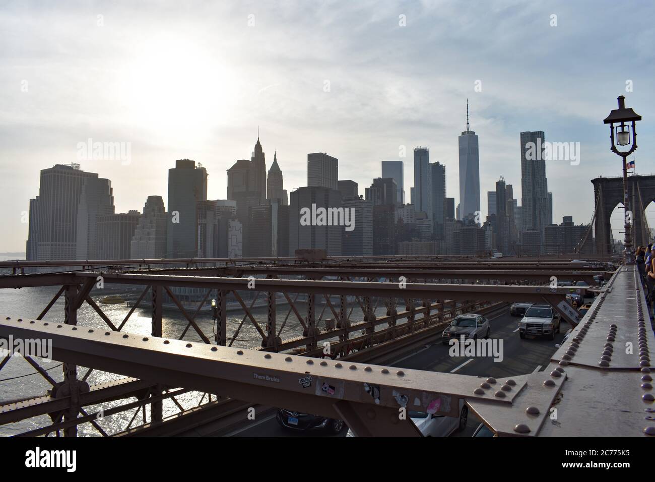 Vue sur la ligne d'horizon du centre-ville, y compris One World Trade Center depuis le pont de Brooklyn, New York. Les voitures passent sous la terrasse piétonne. Banque D'Images