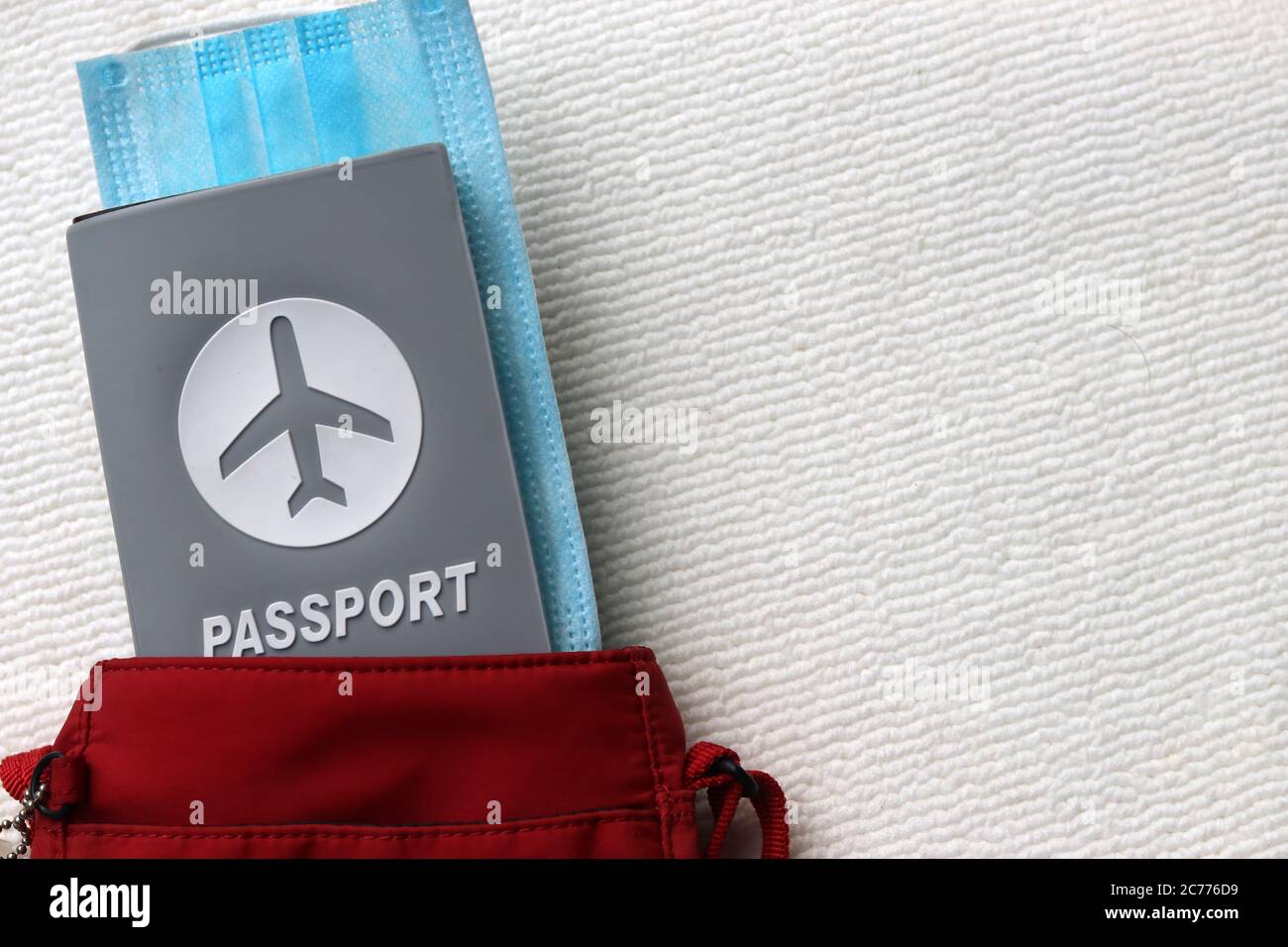 Passeport et masque chirurgical dans un sac rouge à bandoulière avec espace pour les copies sur fond blanc.concept de tourisme et de voyage dans la nouvelle norme après la pandémie Covid-19. Banque D'Images