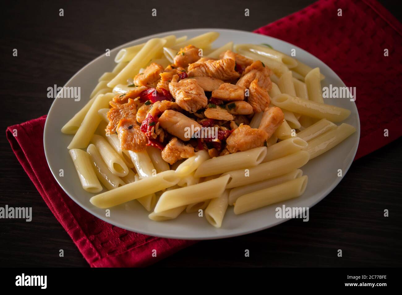 Penne avec poulet et légumes dans une sauce tomate. Plat méditerranéen - pâtes penne au poulet et aux légumes en gros plan Banque D'Images