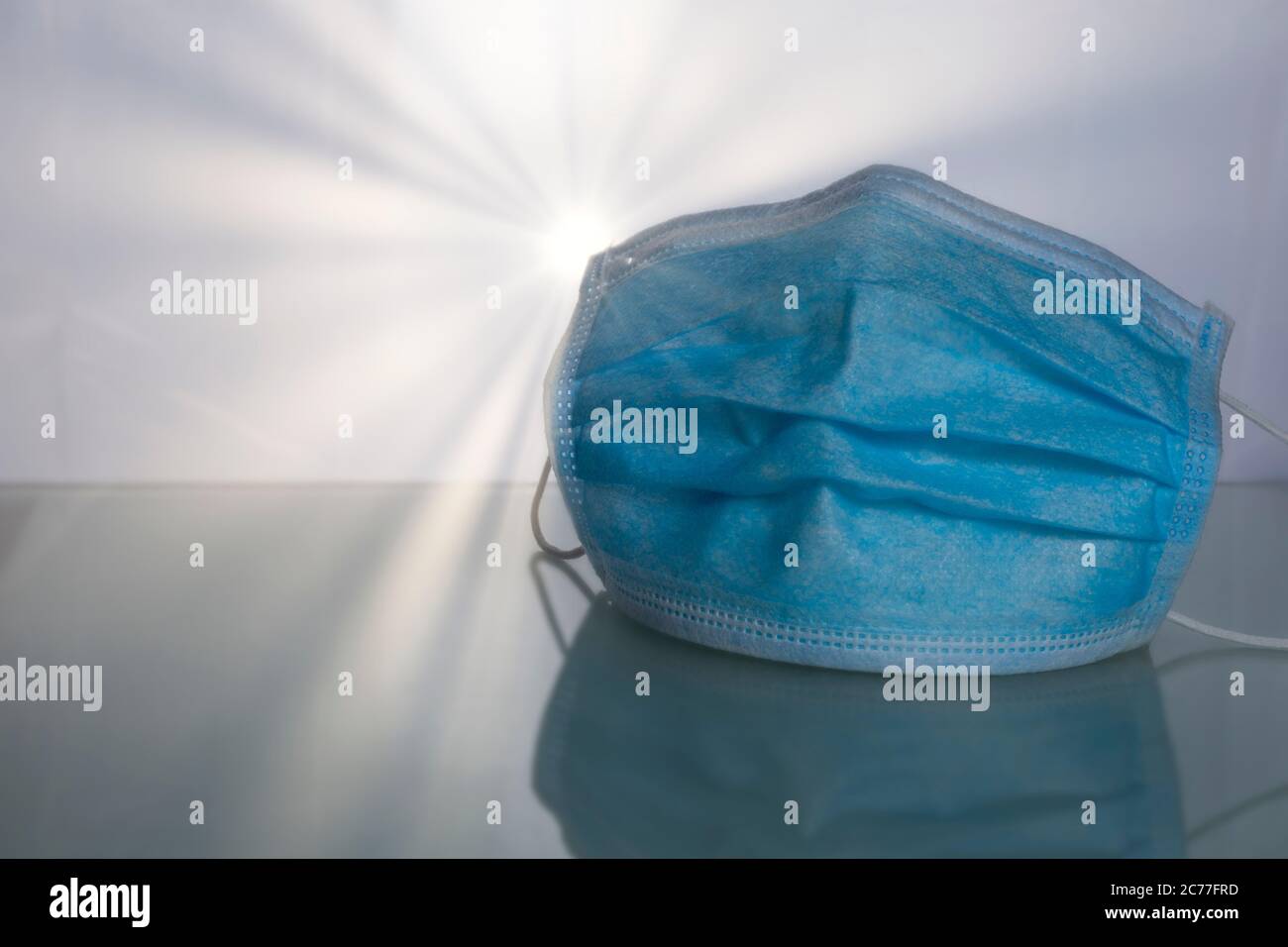 Masque de protection médical sur la table avec fond de rayons solaires. Banque D'Images