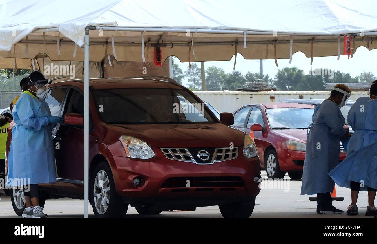 Kissimmee, États-Unis. 14 juillet 2020. Un professionnel de la santé portant un équipement de protection individuelle (EPI) se prépare à effectuer un test COVID-19 sur un site d'essais en voiture au parc Osceola Heritage Park. La Floride continue d'être un point chaud pour les cas de coronavirus et la demande de tests reste également élevée avec plus de 600 personnes visitant ce site aujourd'hui. Crédit : SOPA Images Limited/Alamy Live News Banque D'Images