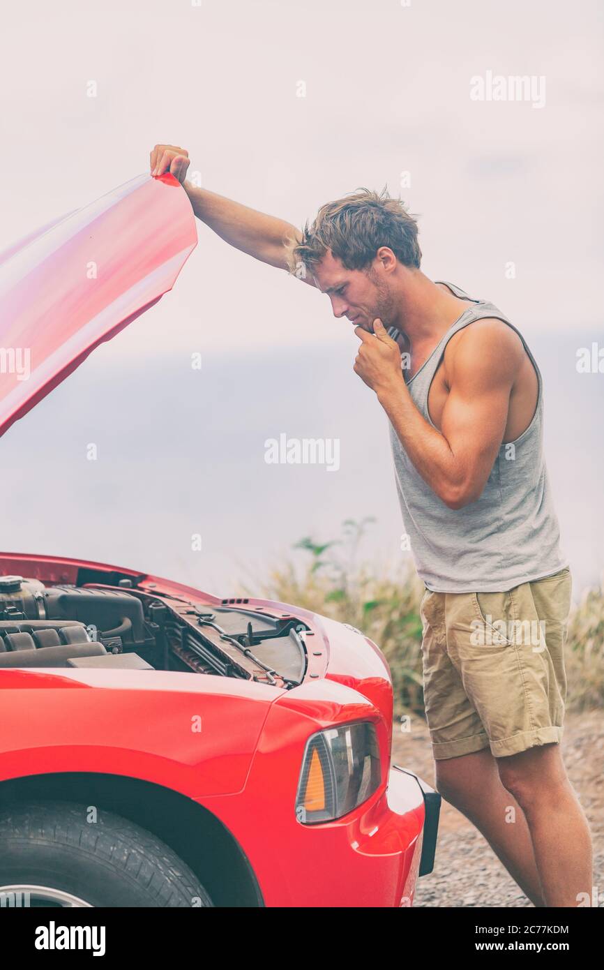 Problème de panne de voiture. Voyage sur route jeune homme sur le côté de la route avec le moteur cassé regardant le moteur dans le capot ouvert réparer le problème Banque D'Images