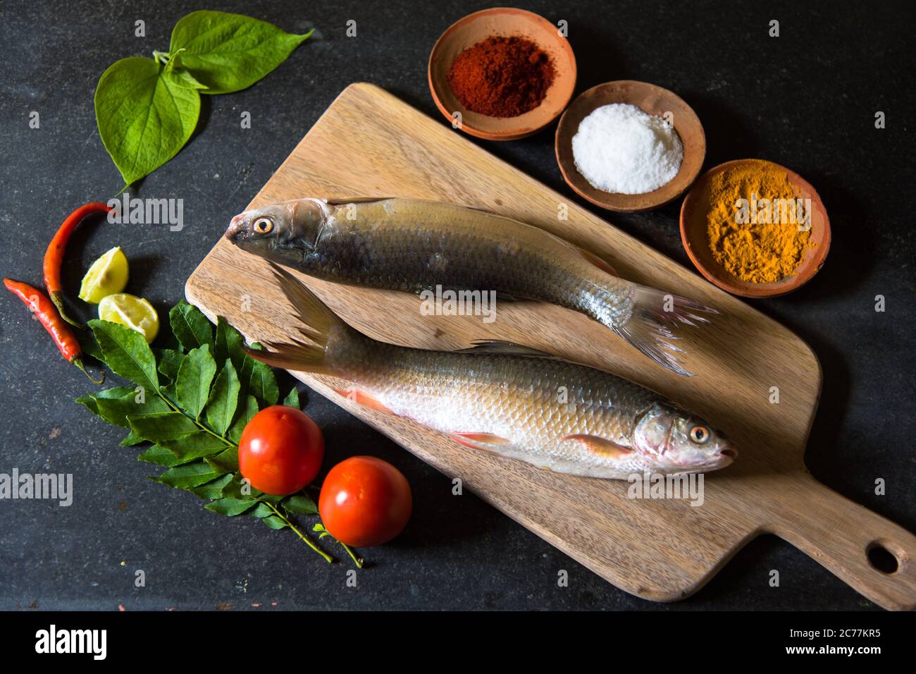 Arrangement de poissons crus avec utilisation de l'accent sélectif sur une partie particulière du poisson et le reste du poisson et d'autres ingrédients flou. Banque D'Images