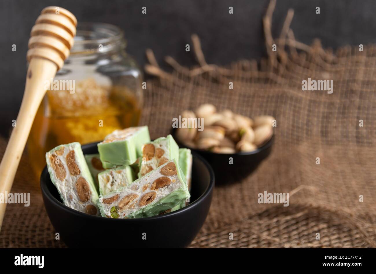 Nougat bio faites avec du miel, pistache, noisette, noix et amandes, sur un fond sombre. rustique Banque D'Images