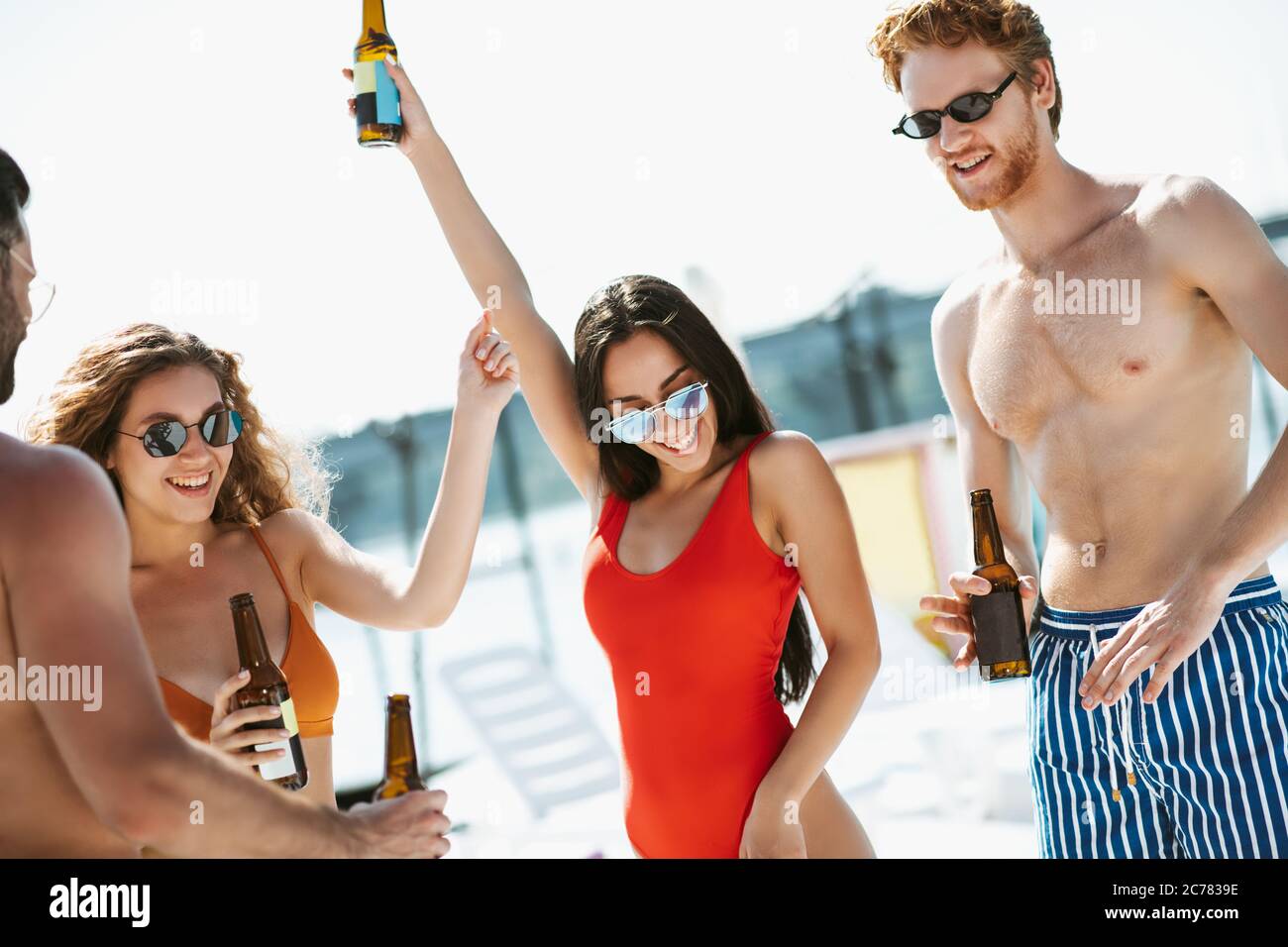 Les jeunes en maillots de bain ont du bon temps à boire de la bière, se sentent excités Banque D'Images