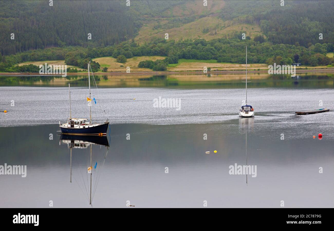 Ballachulish, Lochaber, Écosse, Royaume-Uni. 15 juillet 2020. Après une lourde pluie de nuit, le matin a commencé par la brume sur les collines et les montagnes en arrière-plan, avec peu ou pas de vent sur le Loch Leven permettant des réflexions presque parfaites de la petite embarcation et des conditions parfaites pour le milieu. La pluie s'est mise en place peu après pour accueillir les visiteurs qui s'aventuraient dans la région, car les grands hôtels sont autorisés à ouvrir, ainsi que les pubs et les bars pouvant servir les clients à l'intérieur. Banque D'Images