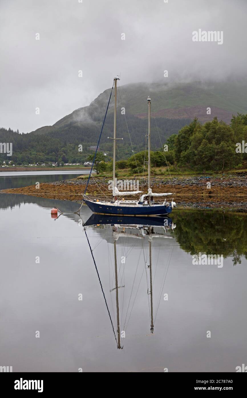 Ballachulish, Lochaber, Écosse, Royaume-Uni. 15 juillet 2020. Après une lourde pluie de nuit, le matin a commencé par la brume sur les collines et les montagnes en arrière-plan, avec peu ou pas de vent sur le Loch Leven permettant des réflexions presque parfaites de la petite embarcation et des conditions parfaites pour le milieu. La pluie s'est mise en place peu après pour accueillir les visiteurs qui s'aventuraient dans la région, car les grands hôtels sont autorisés à ouvrir, ainsi que les pubs et les bars pouvant servir les clients à l'intérieur. Banque D'Images