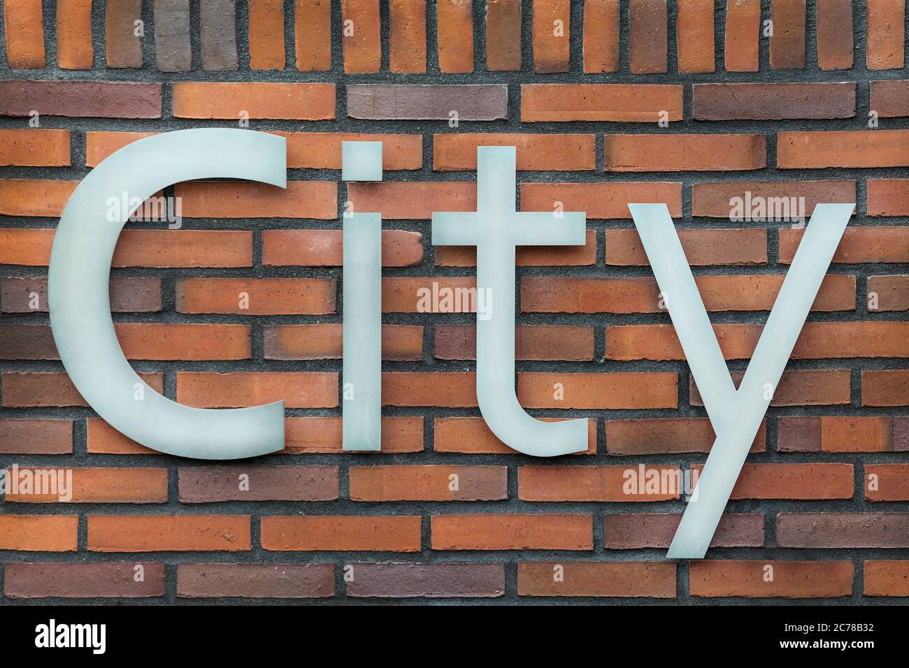 Signe métallique du mot ville sur un mur de briques Banque D'Images