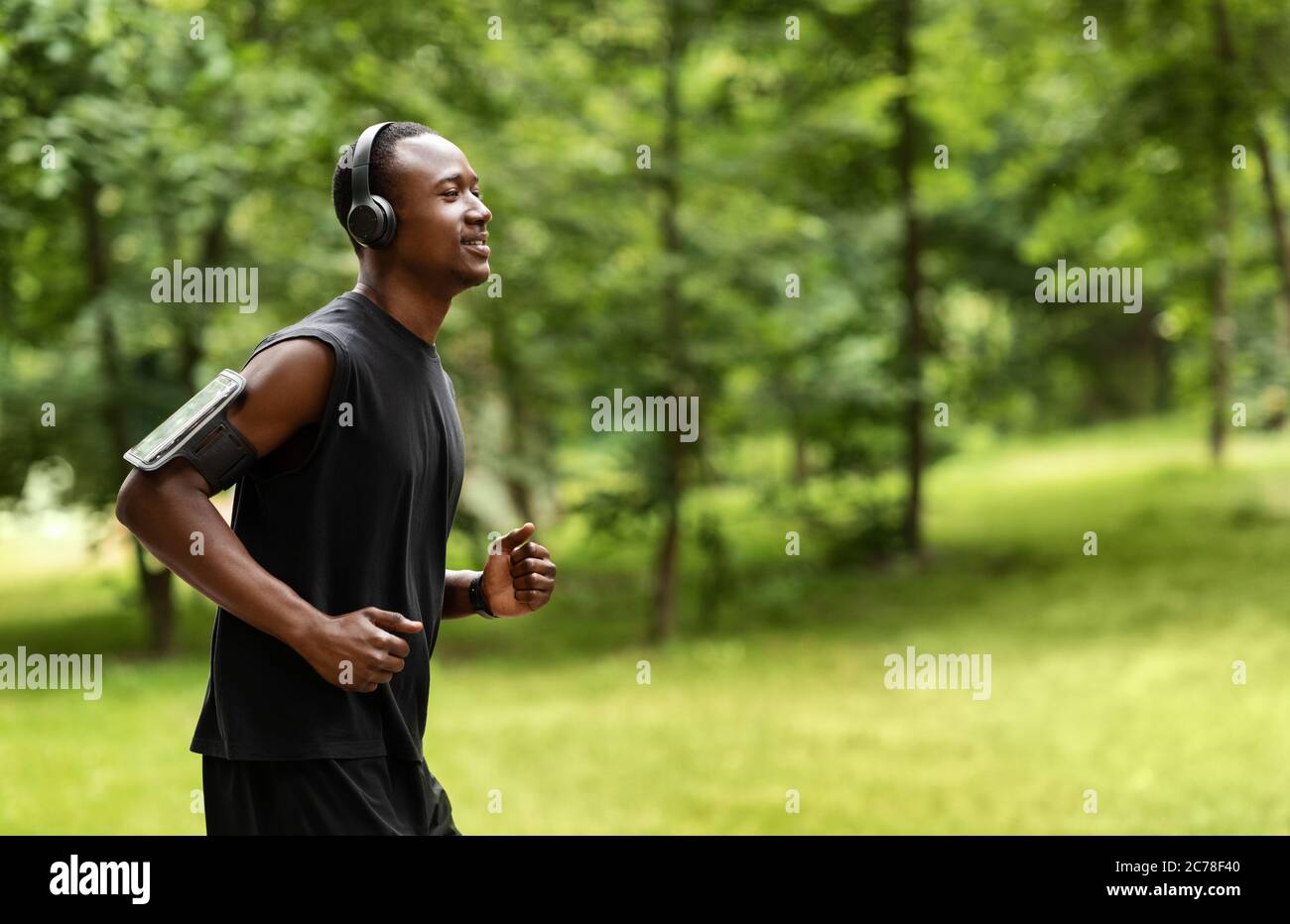 Vue latérale de l'entraînement de jogging africain d'homme au parc Banque D'Images