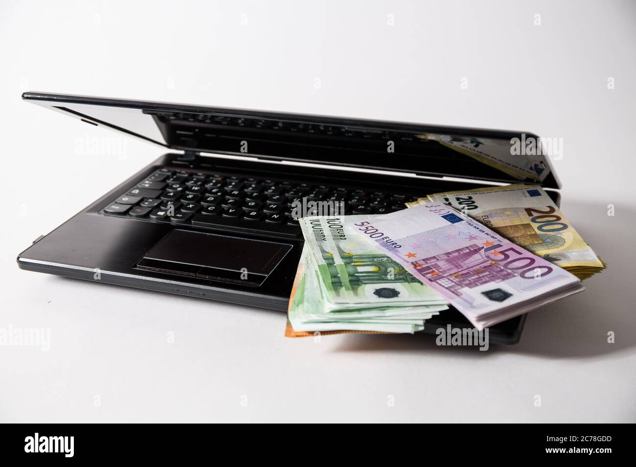 Bamberg, Allemagne 13 juillet 2020: Images de symboles - 2020 plusieurs milliers d'euros en espèces avec les valeurs de 500 euros, 200 euros, 100 euros et 50 euros sont sur un ordinateur portable Internet crime, cybercriminalité, | utilisation dans le monde entier Banque D'Images