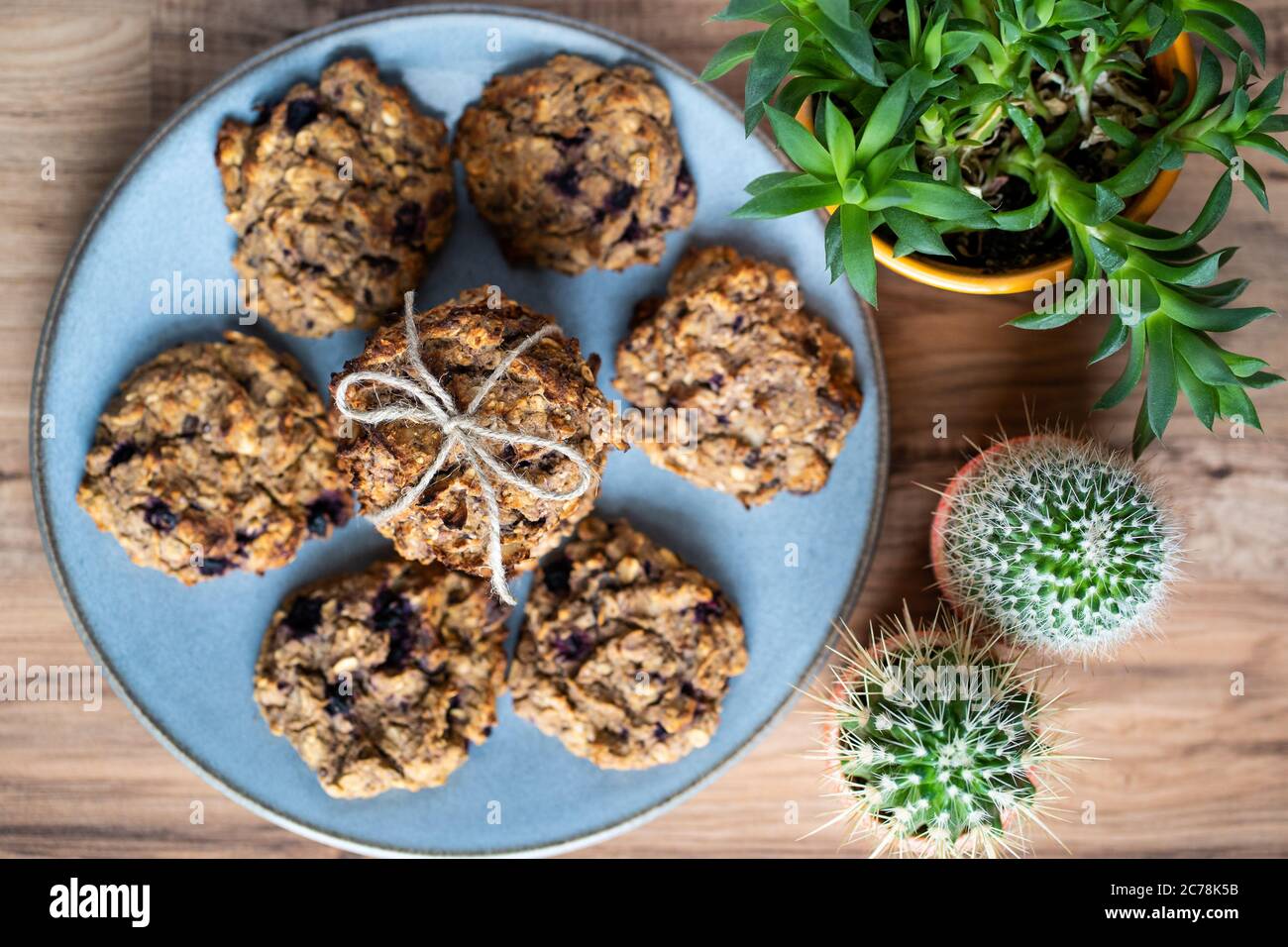 Ensemble de biscuits maison aux flocons d'avoine et aux myrtilles, faciles à préparer et sains, sur une belle assiette bleue. Les biscuits sont noués et décorés de ficelle. Banque D'Images