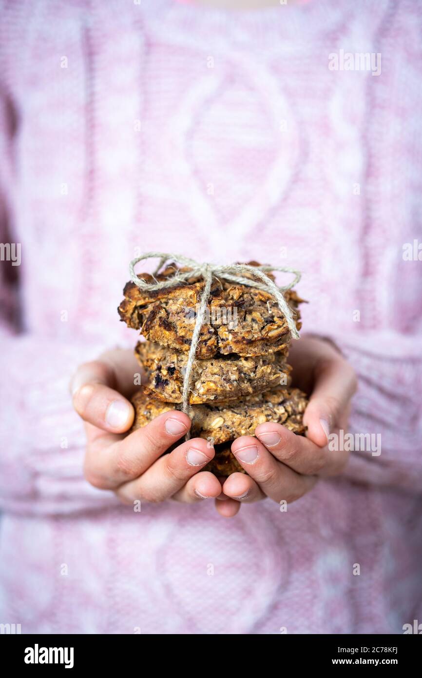 Enfant dans le chandail rose est facile à préparer et sain, flocons d'avoine maison et biscuits aux myrtilles. Banque D'Images