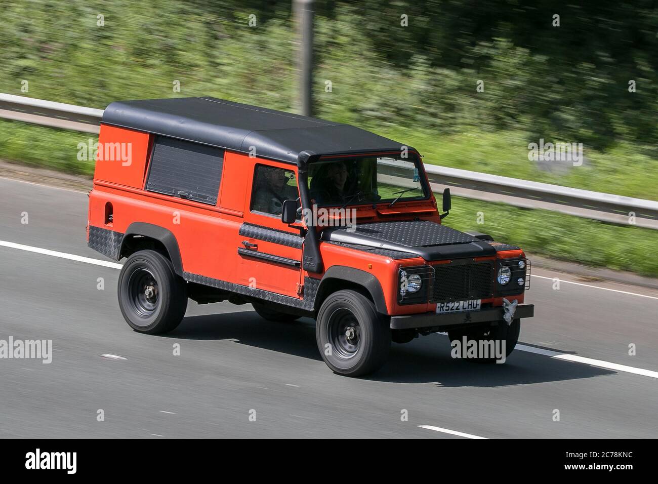 Un Land Rover 110 Defender TDI Orange LCV Hardtop Van Diesel 1997 roulant sur l'autoroute M6 près de Preston à Lancashire, Royaume-Uni Banque D'Images